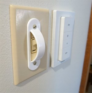 Ein Philips Hue Zigbee-Dimmer-Schalter neben einem Wandschalter montiert
